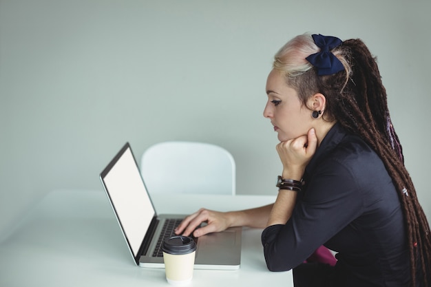 Donna che per mezzo del computer portatile