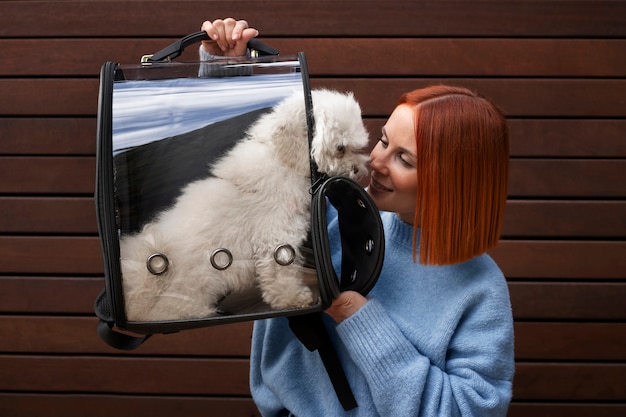 Donna che porta il suo cane in una speciale borsa da trasporto