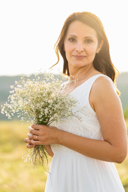 Donna che posa all'aperto con i fiori