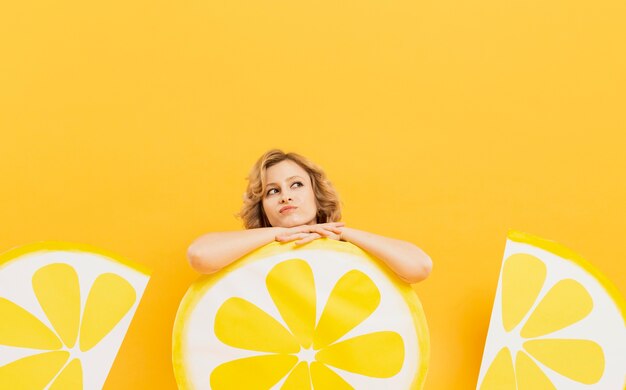 Donna che posa mentre riposa sulle decorazioni delle fette del limone