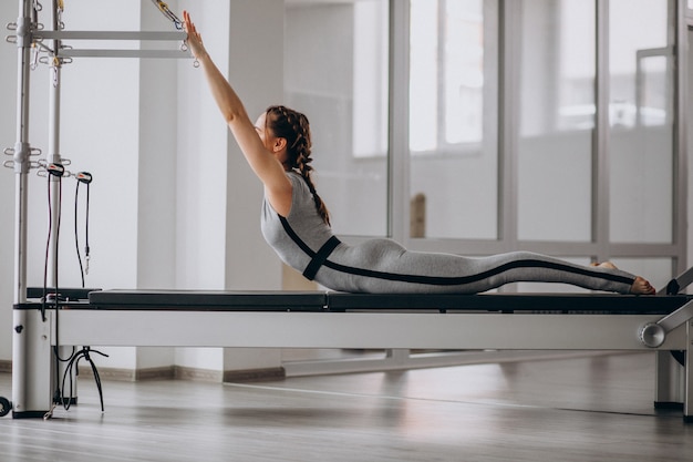 Donna che pratica pilates in un riformatore di pilates