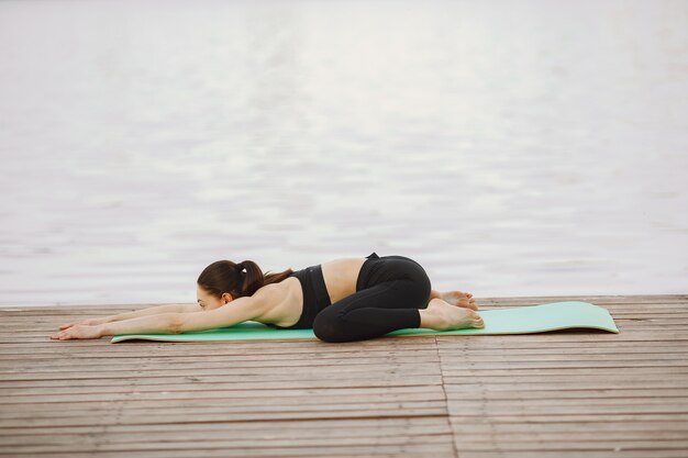 Donna che pratica yoga avanzato dall'acqua