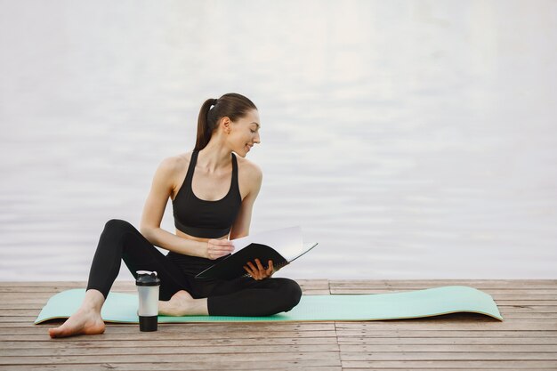 Donna che pratica yoga avanzato dall'acqua