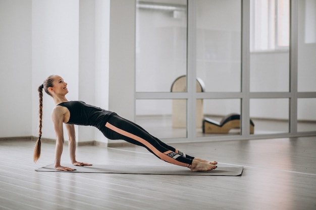 Donna che pratica yoga in palestra su una stuoia