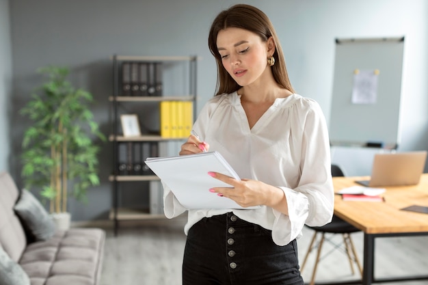 Donna che prende appunti sul suo taccuino al lavoro