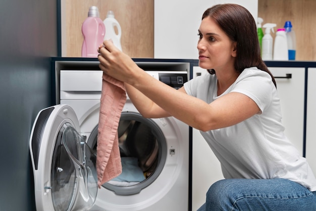Donna che prende i vestiti dalla lavatrice