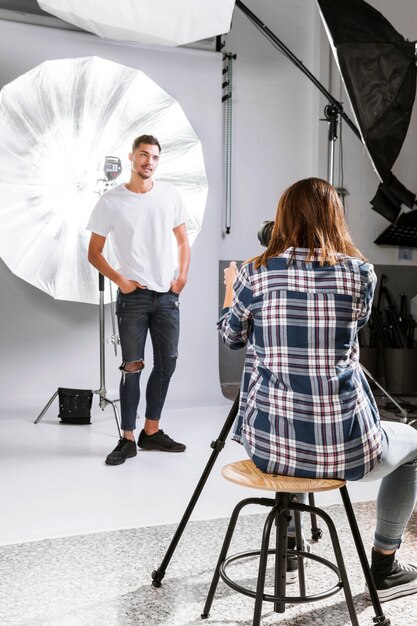 Donna che prende le foto dell'uomo bello in studio