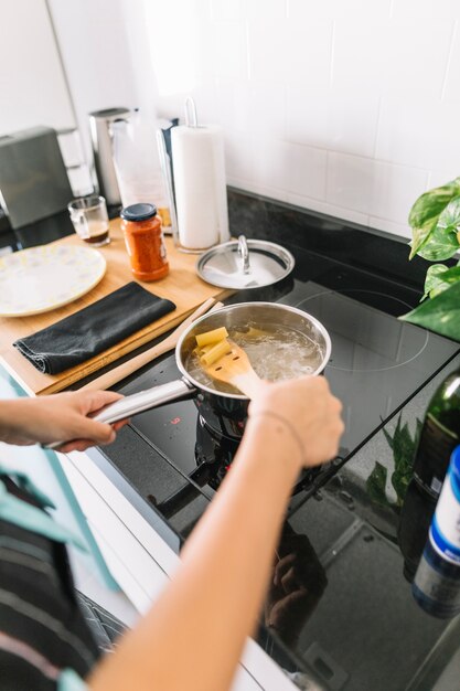 Donna che prepara la pasta di rigatoni in casseruola