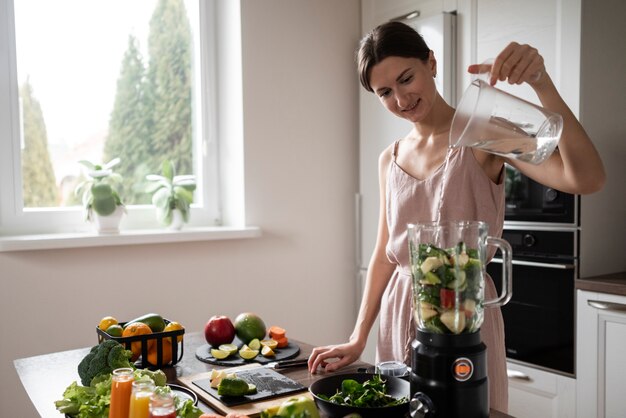 Donna che prepara la sua ricetta del succo