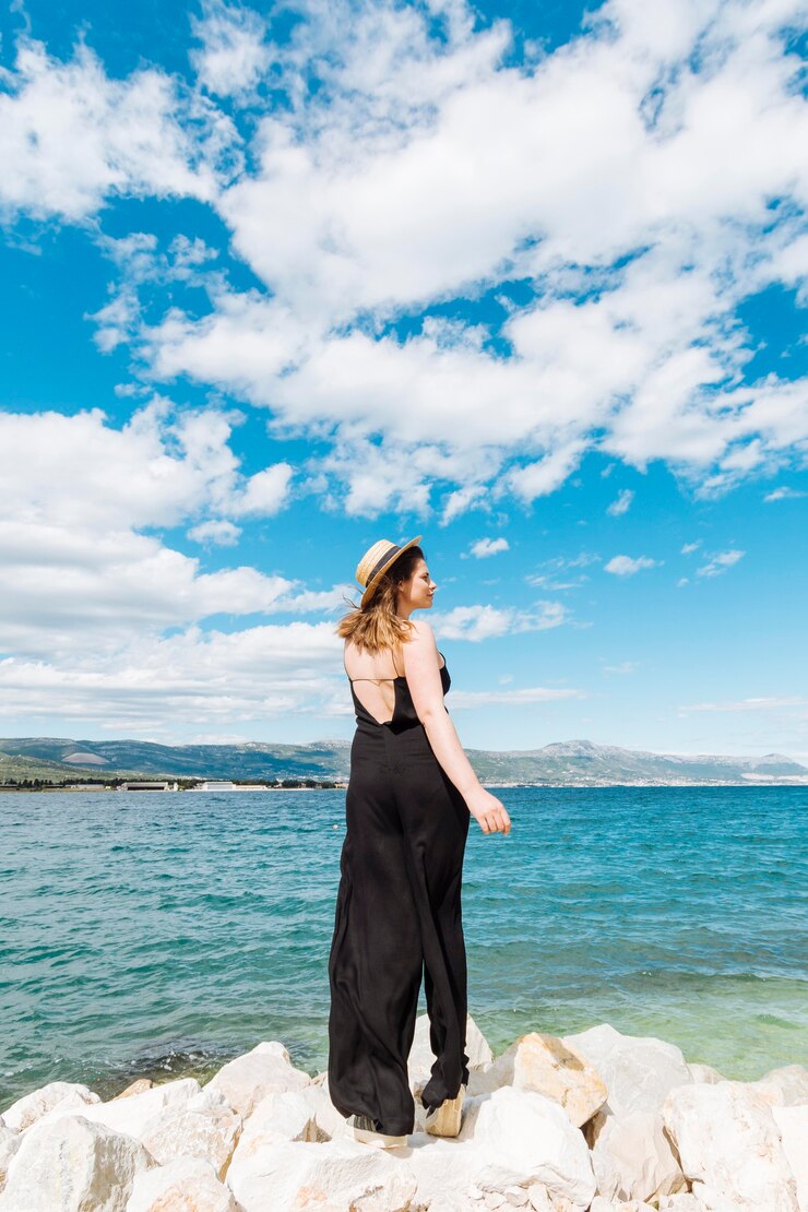 Foto gratuito donna che propone il bello giorno vicino all'oceano
