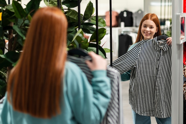 Donna che prova una camicia alla moda