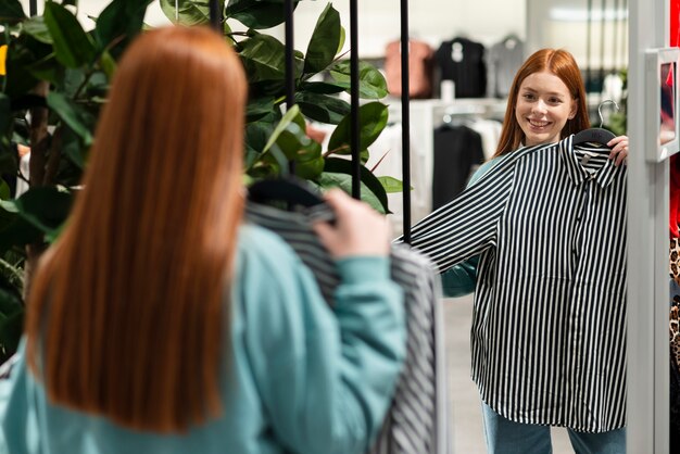 Donna che prova una camicia alla moda