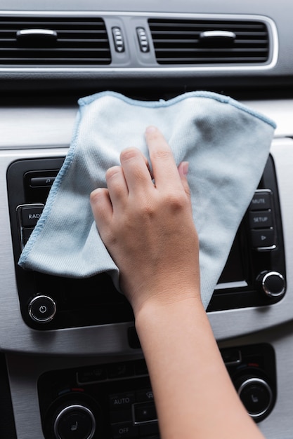 Donna che pulisce il suo primo piano dell'automobile