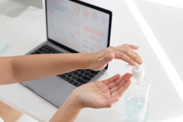 Donna che pulisce le mani con un gel disinfettante per le mani per prevenire la contaminazione da coronavirus