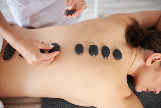 Donna che riceve un massaggio alla schiena con pietre calde