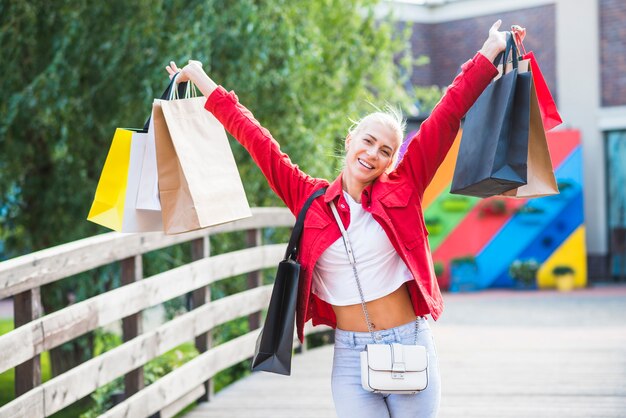 Donna che ride con i pacchetti dello shopping