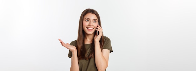 Donna che ride parlando e mandando messaggi di testo al telefono isolato su uno sfondo bianco