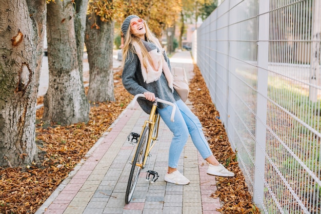 Donna che ride sulla bicicletta vicino al recinto