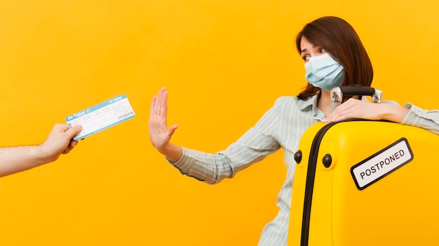 Donna che rifiuta un biglietto aereo mentre indossa maschera medica