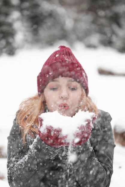 Donna che salta in un mucchio della vista frontale della neve