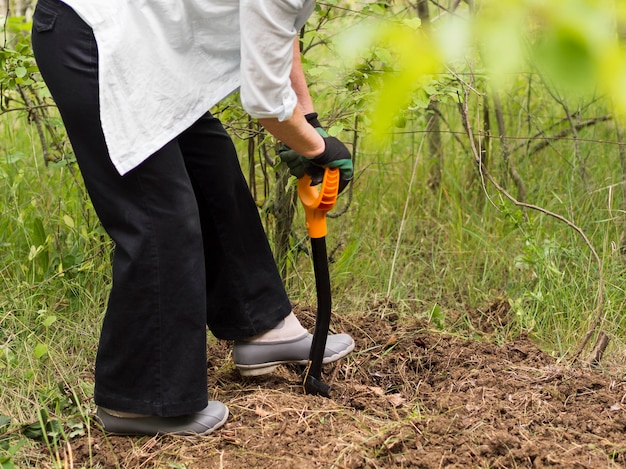 Donna che scava nel suo giardino