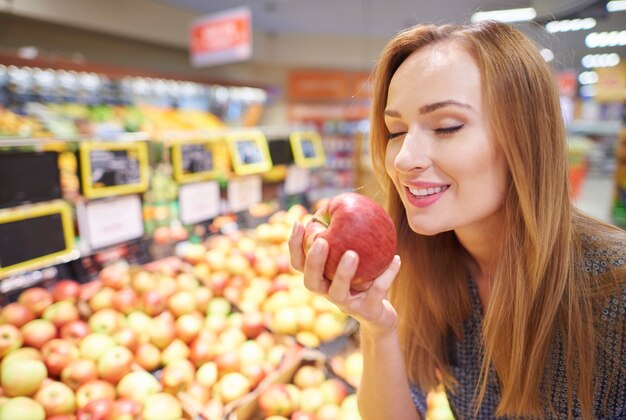 Donna che sceglie le mele dal negozio di alimentari