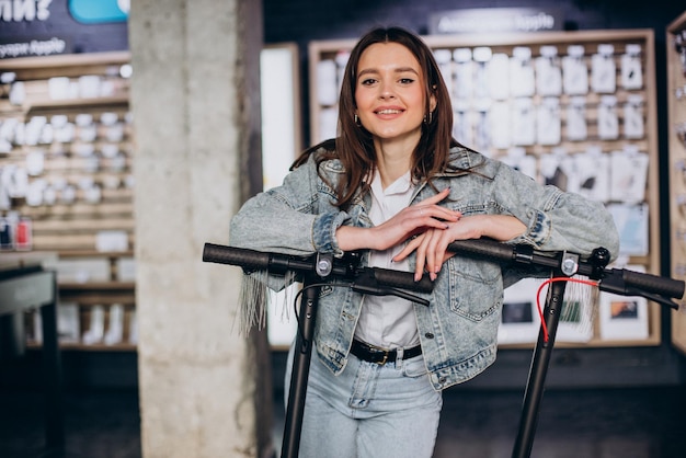 Donna che sceglie uno scooter al negozio di tecnologia