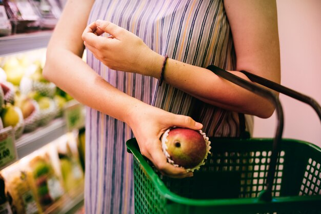 Donna che seleziona una mela al supermercato