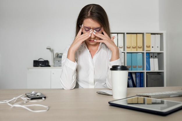 Donna che sembra stanca al lavoro a causa del tempo trascorso al telefono