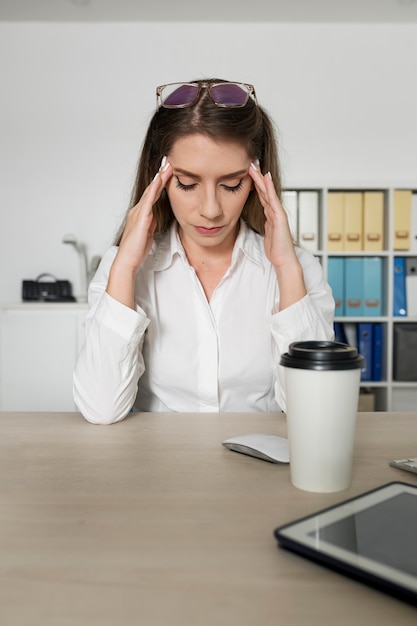 Donna che sembra stanca al lavoro a causa del tempo trascorso al telefono