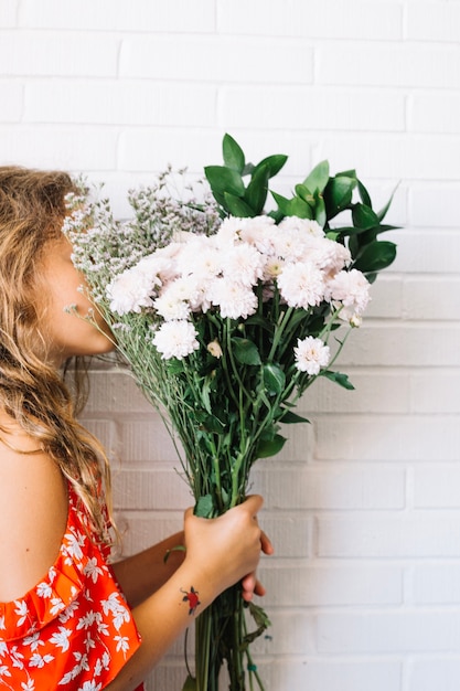 Donna che sente l&#39;odore dei fiori