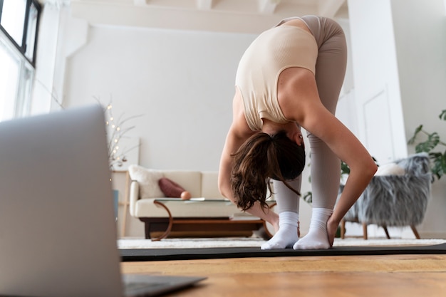 Donna che si allena dopo un istruttore di fitness online