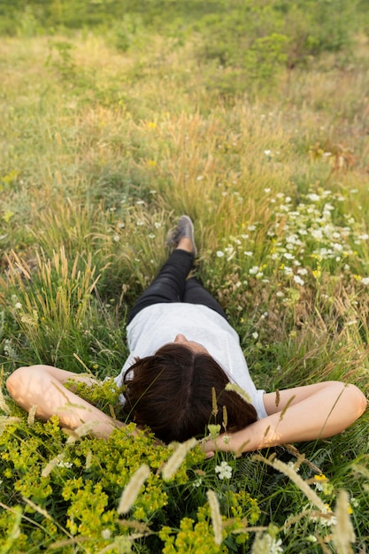 Donna che si distende in natura sull'erba