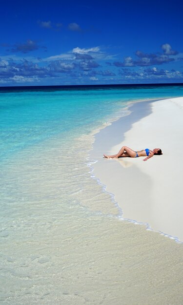 Donna che si distende sulla vacanza della spiaggia