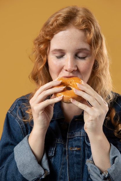 Donna che si diverte a mangiare una ciambella