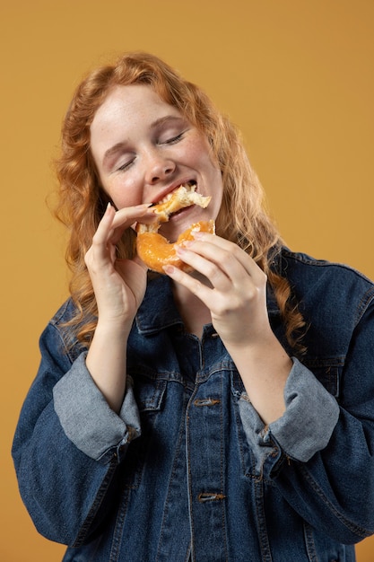 Donna che si diverte a mangiare una ciambella