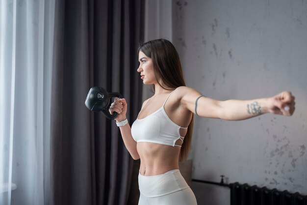 Donna che si esercita con il colpo medio del kettlebell