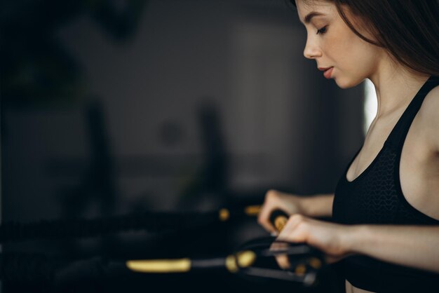 Donna che si esercita in palestra usando corde elastiche