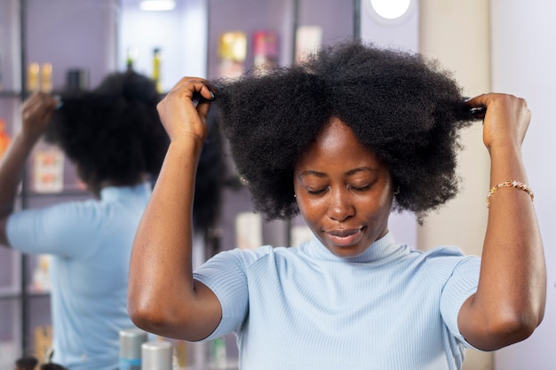 Donna che si prende cura dei suoi capelli afro
