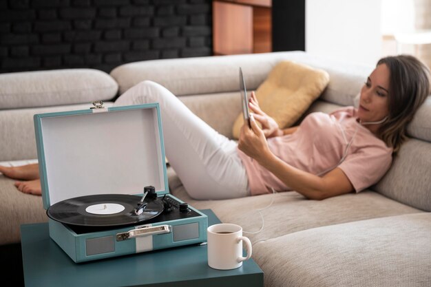 Donna che si rilassa a casa mentre ascolta musica in vinile