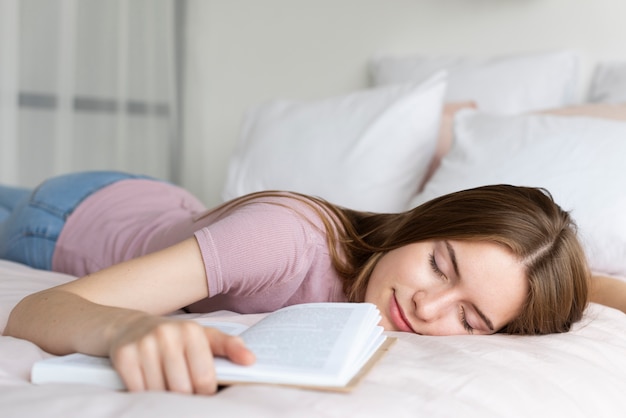 Donna che si rilassa a letto con un libro