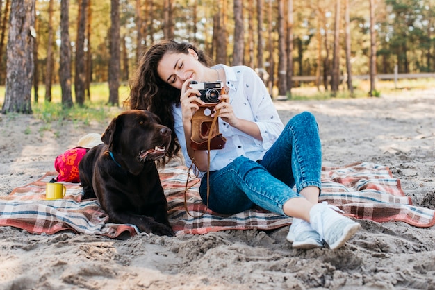 Donna che si siede con il suo cane in natura