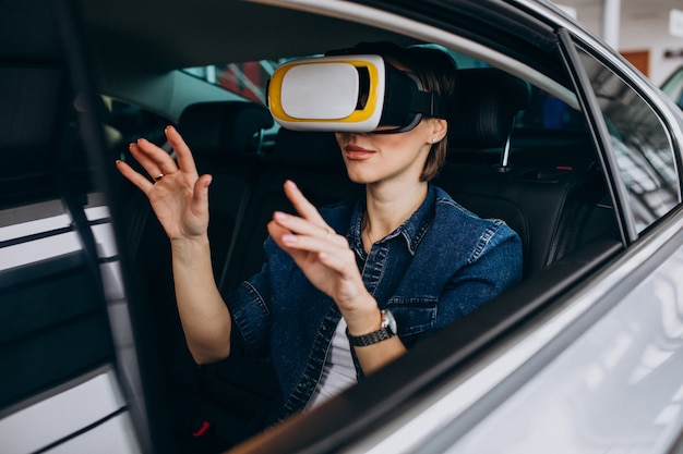 Donna che si siede dentro un'automobile che indossa i vetri del vr