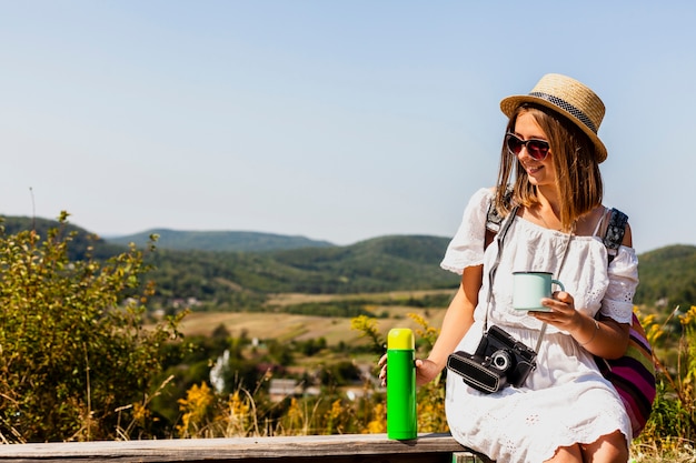 Donna che si siede e che gode di un caffè