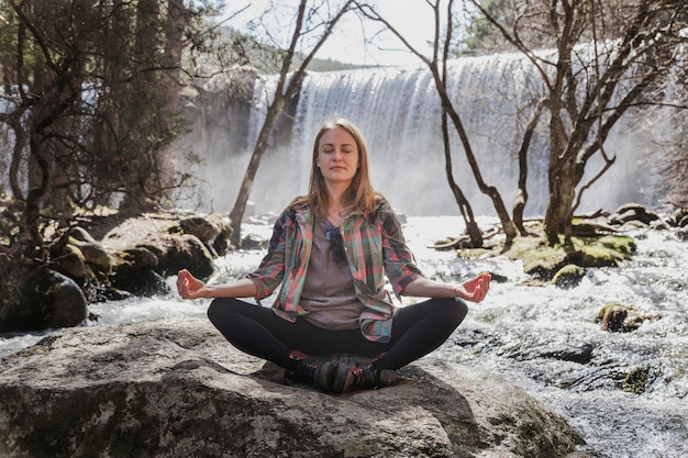 Donna che si siede nella posizione di yoga all&#39;aperto