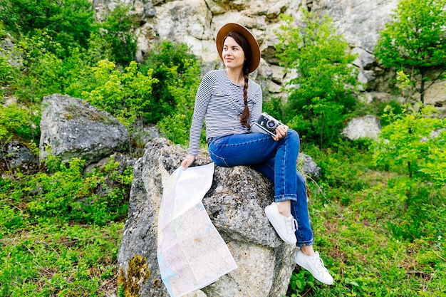 Donna che si siede sulla roccia in natura