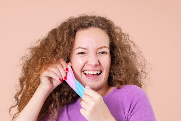 Donna che si toglie la maschera durante la nuova normalità