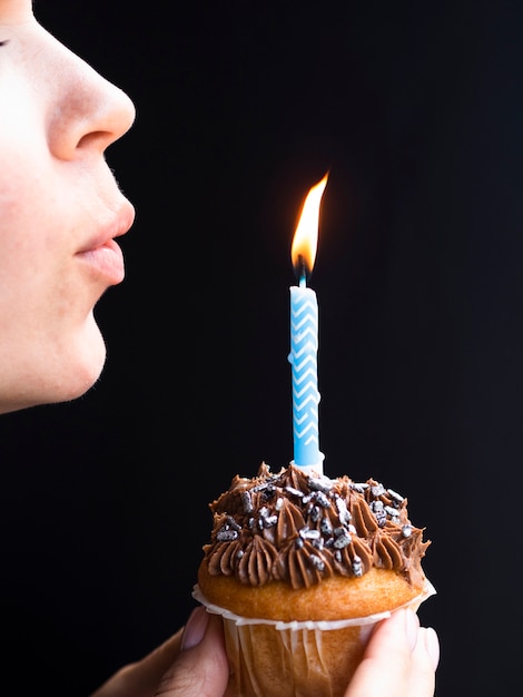 Donna che soffia in una candela di compleanno