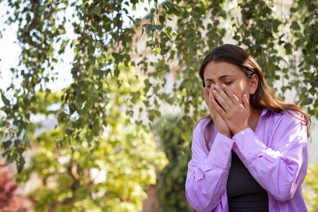 Donna che soffre di allergie all'esterno