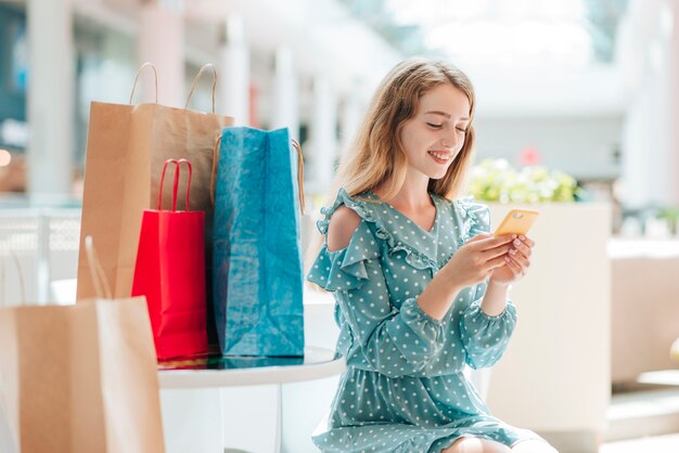 Donna che sorride e che controlla il suo telefono